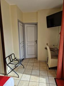ViviersにあるLe Relais du Vivaraisのドア、椅子、デスクが備わる客室です。