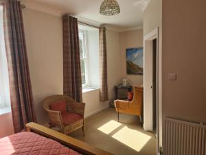 a bedroom with a bed and two chairs and a window at Cuffern Manor in Roch