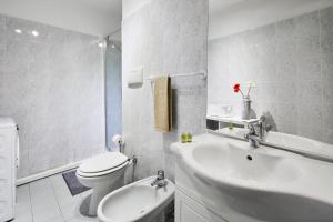 uma casa de banho branca com um WC e um lavatório em House Naviglio Grande 15 minutes to duomo em Milão