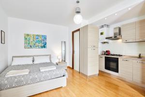 um quarto branco com uma cama e uma cozinha em House Naviglio Grande 15 minutes to duomo em Milão