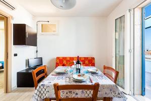 una sala da pranzo con tavolo e sedie e una cucina di DORMIGLIONE APARTMENT a Torre Lapillo