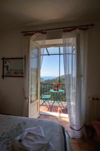 een slaapkamer met een bed en een balkon met een tafel bij Le Case di Petra in Vignana