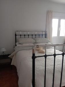 sypialnia z łóżkiem z białą pościelą i poduszkami w obiekcie Casa Rural Olivares w mieście Villanueva de Algaidas