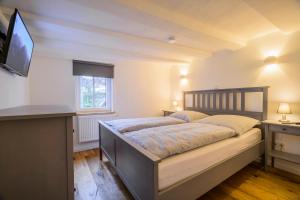 1 dormitorio con 2 camas y TV. en Gästeappartements Mechels en Wilnsdorf