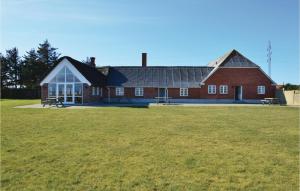 un grand bâtiment en briques rouges avec une grande pelouse dans l'établissement Stunning Home In Ringkbing With Kitchen, à Klegod