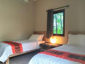 塞隆貝拉納克的住宿－Villa Jeruk，一间卧室设有两张床和彩色玻璃窗。