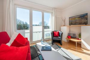 ヘリングスドルフにあるForum Marinar 25のリビングルーム(赤い家具、大きな窓付)