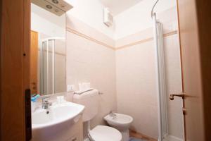 y baño con aseo, lavabo y ducha. en Le Case di Petra, en Vignana