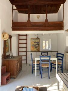 a dining room with a white table and blue chairs at Little Blue in Chorio, Symi in Symi