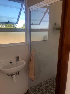 a bathroom with a sink and a window at Fynbos Tiny Home - Off Grid, Surrounded by Nature in Plettenberg Bay