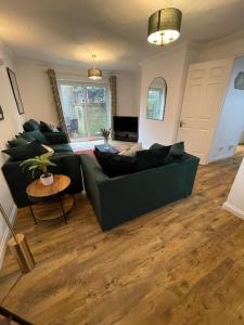 a living room with a green couch and a table at St Dunstan's Hideaway in Canterbury