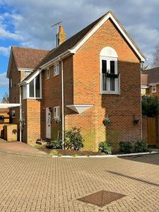a brick house with a white window and a brick driveway at St Dunstan's Hideaway in Canterbury