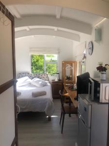 1 dormitorio con 1 cama y escritorio con ordenador en Fynbos Tiny Home - Off Grid, Surrounded by Nature, en Plettenberg Bay