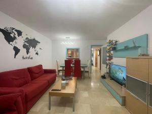 a living room with a red couch and a world map on the wall at Traveler's Beach Apartment with sea view, free coffee & parking in Benidorm
