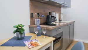 a small kitchen with a table with two glasses of wine at Quartier1 in Zeven