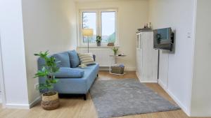 sala de estar con sofá azul y TV en Quartier3, en Zeven