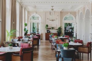a restaurant with tables and chairs and a chandelier at The Queens Hotel in Portsmouth