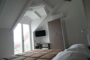 Dormitorio con cama, escritorio y TV en Acqua Leggia en Agerola