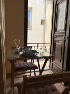 a dining room table with a glass table top at GK Apartment in Chios