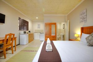 1 dormitorio con 1 cama grande y cocina en Eagles Nest Guesthouse, en Eshowe