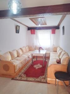 - un salon avec un canapé et une table dans l'établissement Havre de Paix chez Lamine, à Harhoura