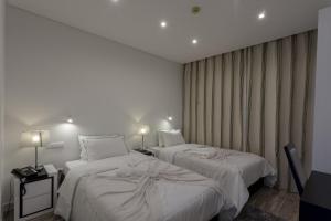 a hotel room with two beds and two lamps at Quinta de Santa Bárbara Casas Turisticas in Lagoa +133 photos