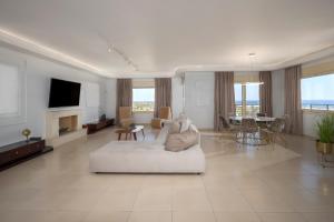 a living room with a white couch and a tv at Villa Melissa by Estia in Hersonissos