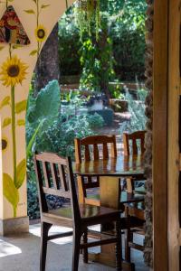 une table et des chaises en bois avec un jardin en arrière-plan dans l'établissement Kiwavi Home, à Moshi
