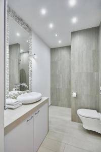 bagno con servizi igienici, lavandino e specchio di Apartament w Paski - z tarasem - Playa Baltis a Międzyzdroje