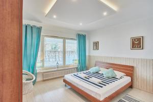 una camera da letto con un letto con tende blu e una finestra di Apartament w Paski - z tarasem - Playa Baltis a Międzyzdroje
