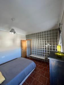 a bedroom with a bed and a tiled wall at La Casita in Ardales
