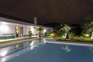 a villa with a swimming pool at night at Quinta de Santa Bárbara Casas Turisticas in Lagoa