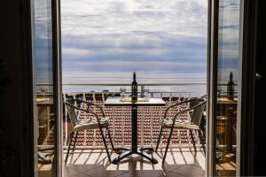una mesa y sillas en un balcón con vistas al océano en Apartments Imperijal Dubrovnik, en Dubrovnik