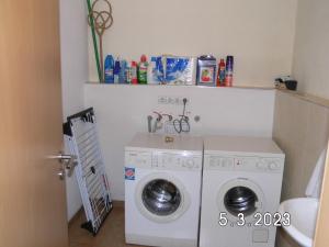 RadeburgにあるPension Jucundaの小さな部屋に洗濯機と乾燥機があります。