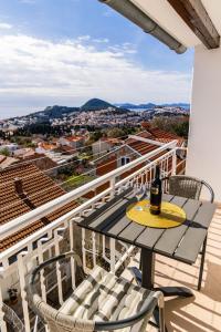 a table and chairs on a balcony with a bottle of wine at Apartments Imperijal Dubrovnik in Dubrovnik