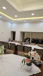 a conference room with tables and chairs with flowers in a vase at فندق مرسى جيزان in Jazan