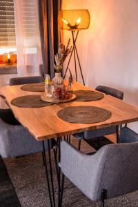 een houten tafel met vier stoelen eromheen bij Viktoria‘s Ferienwohnung in Bad Harzburg