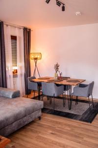 een woonkamer met een tafel en stoelen en een bank bij Viktoria‘s Ferienwohnung in Bad Harzburg