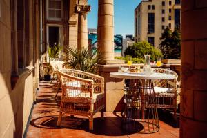 a patio with two chairs and a table on a balcony at The Queens Hotel in Portsmouth