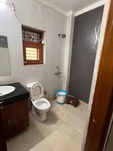 a bathroom with a toilet and a sink at Entire floor 2BHK with full Kitchen Near Medanta hospital in Gurgaon
