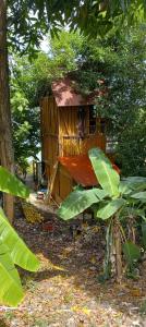 una pequeña casa en el árbol con techo de paja en treehouse above the beach en Port Antonio