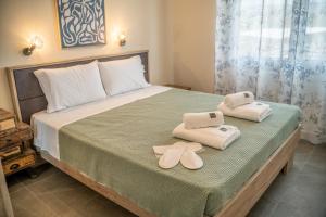 a bedroom with a bed with towels on it at Villa Eva Dikella in Mesimvría