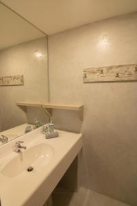 uma casa de banho com um lavatório branco e um espelho. em The Mountain House em Tourlotí