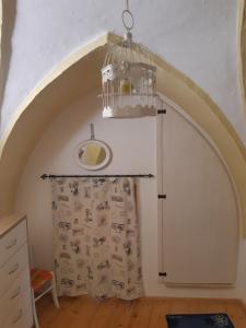 Zimmer mit einem Kronleuchter und einer Wand mit einer Tür in der Unterkunft Morgana in Casarano