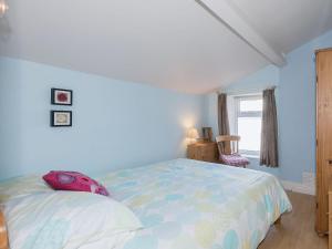 a bedroom with a bed and a window at Lazy Cottage in Haverigg
