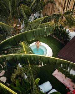 a man in a swimming pool with palm trees at VILLA LA ISLA BONITA walking distance to the beach in Gili Air
