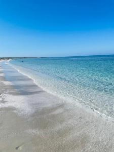 una playa con agua clara y un cielo azul en B&B Tre, en Oristano