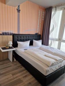 a bedroom with a large bed with a black headboard at MIDTOWN Apartments in Stuttgart