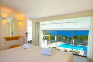 a bedroom with a bed and a view of a pool at Mirabella Hills in Agios Nikolaos