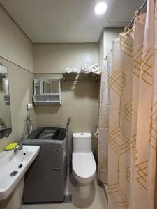 un piccolo bagno con servizi igienici e lavandino di The Estrella Suite at the Mall of Asia Complex a Manila